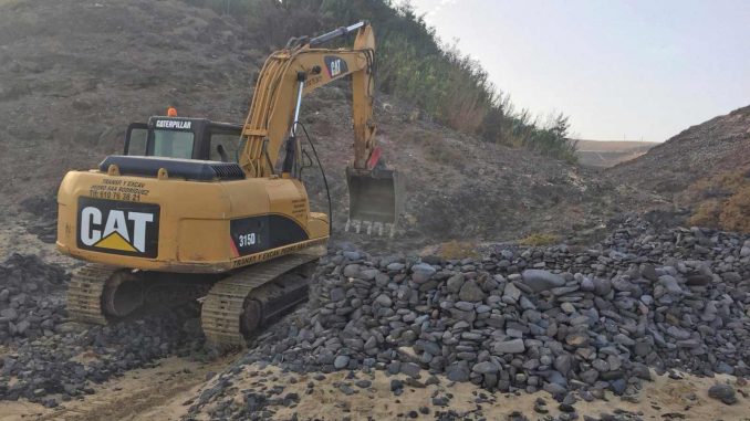 Bagger reißt Steinburg am Strand von Fuerteventura ein